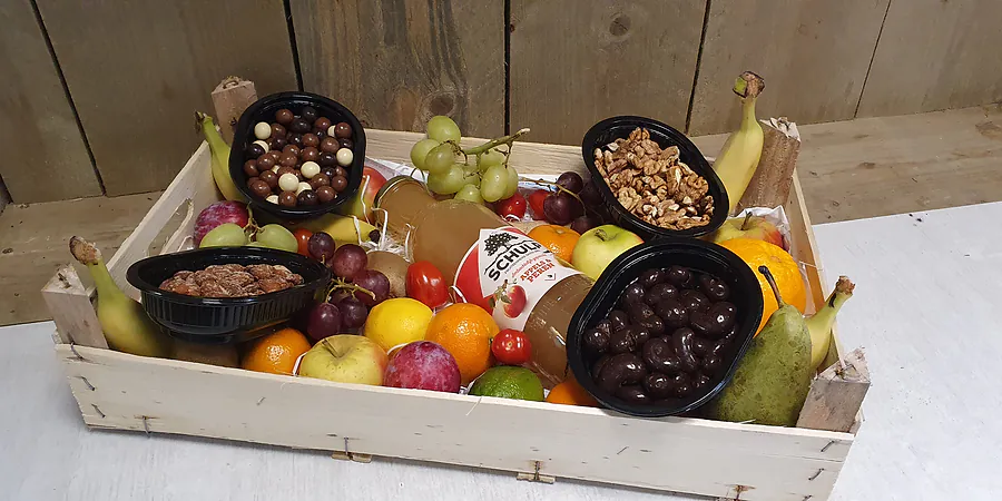 De fruit-notenmix box: een grenen kistje met fruit, noten, dadels en chocolade op Joe's plank.